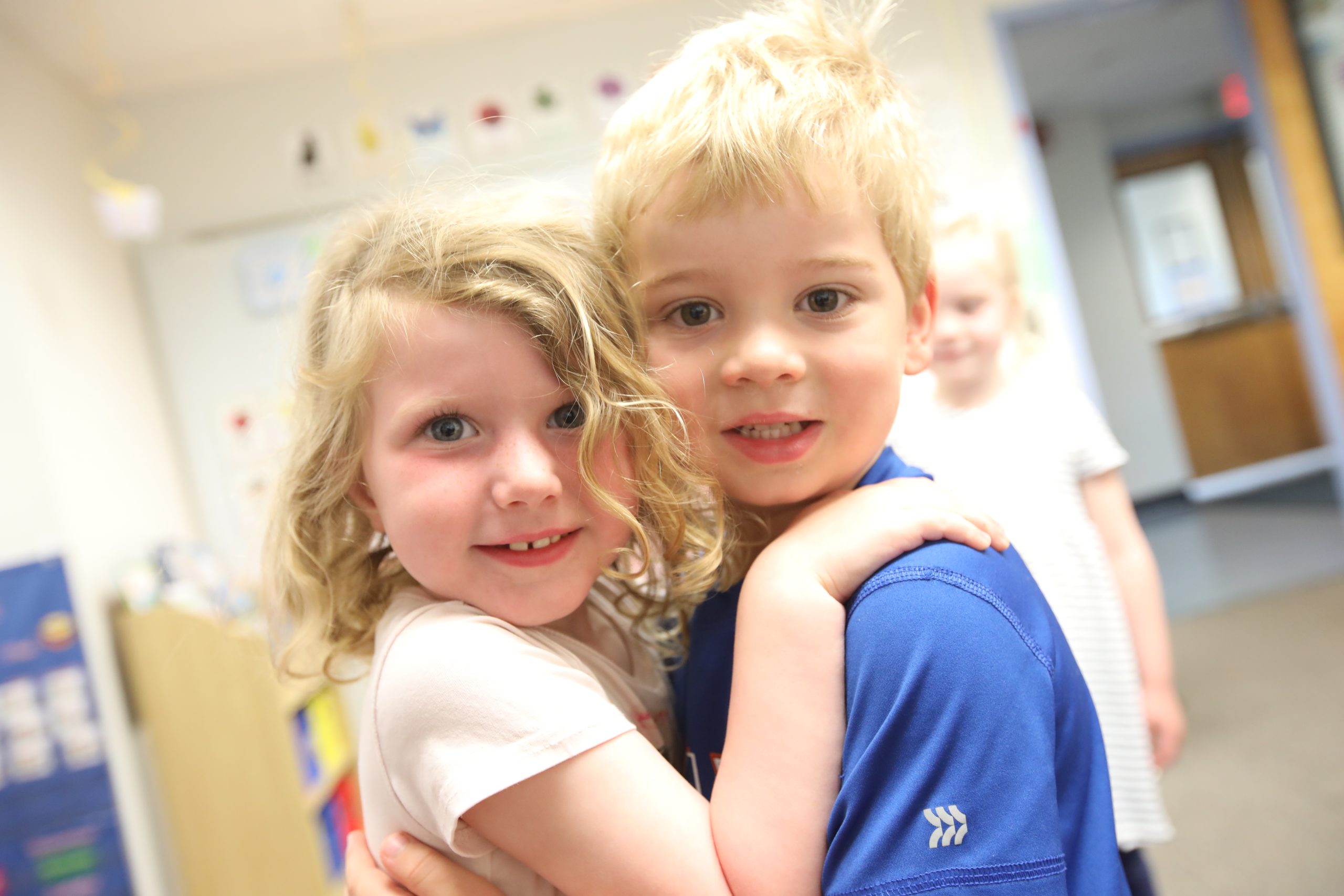 two preschool buddies hugging