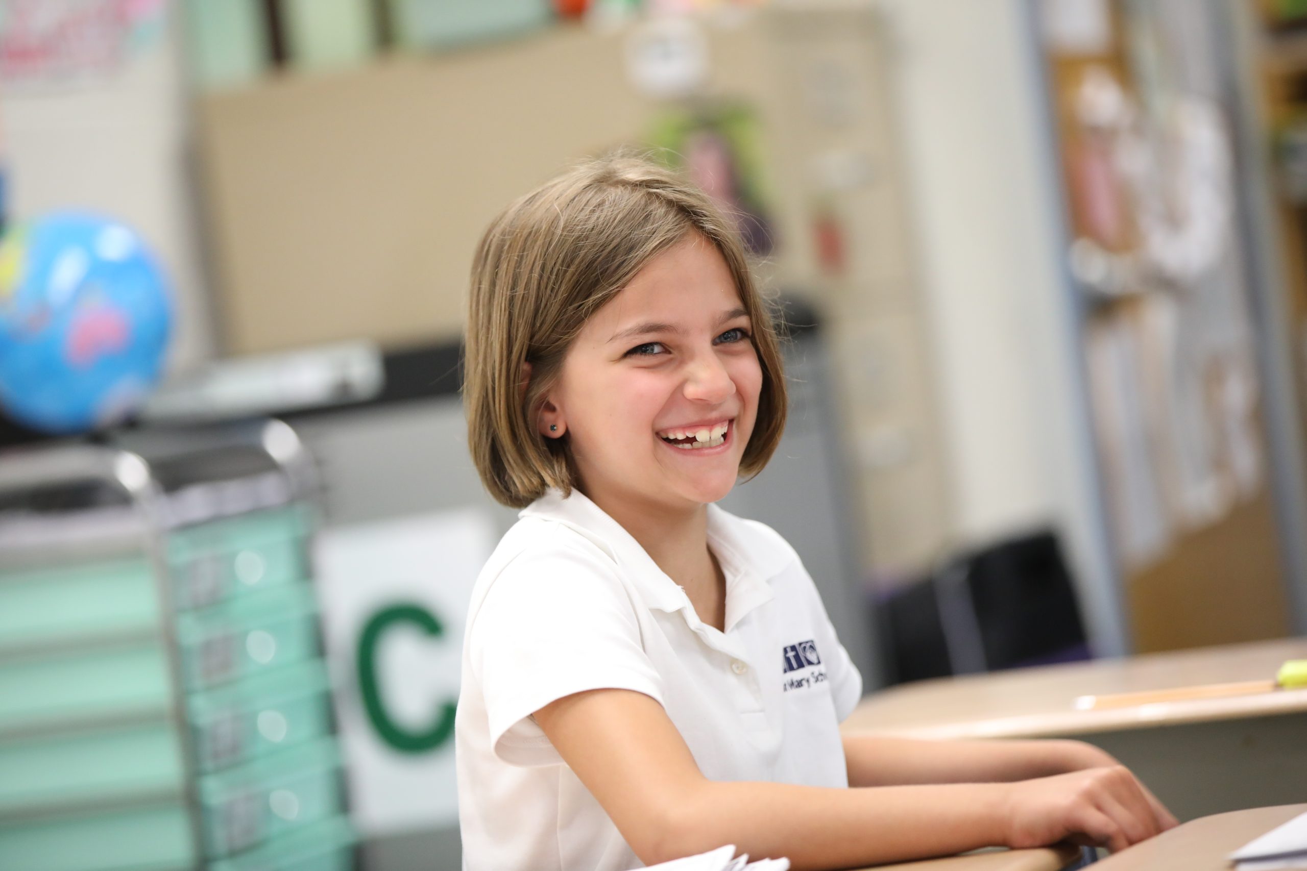 Student smiling while sitting at desk