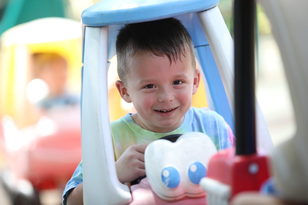 preschooler playing in toy car