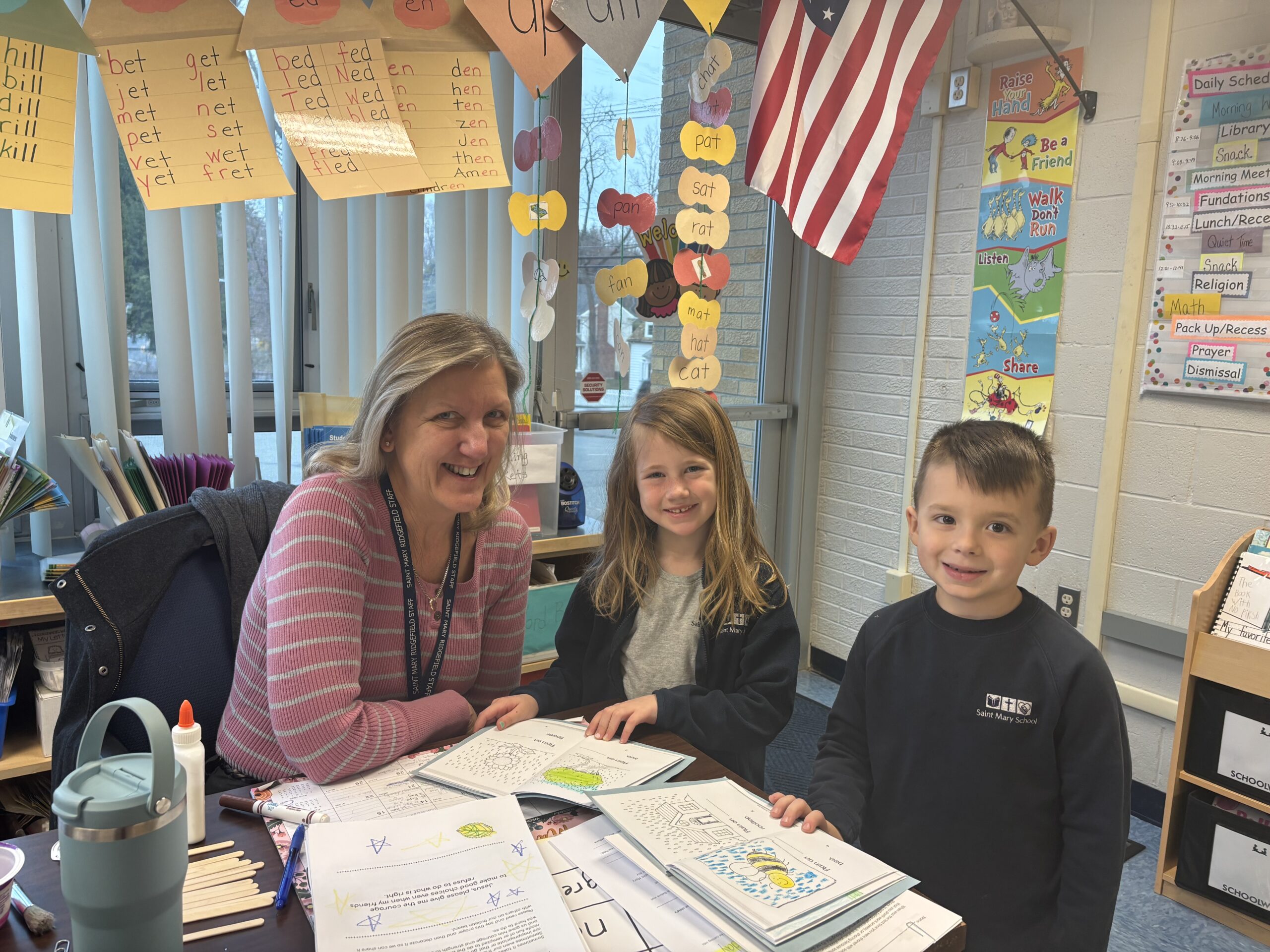 Kindergarten Assistant Jean Lombardo with two students