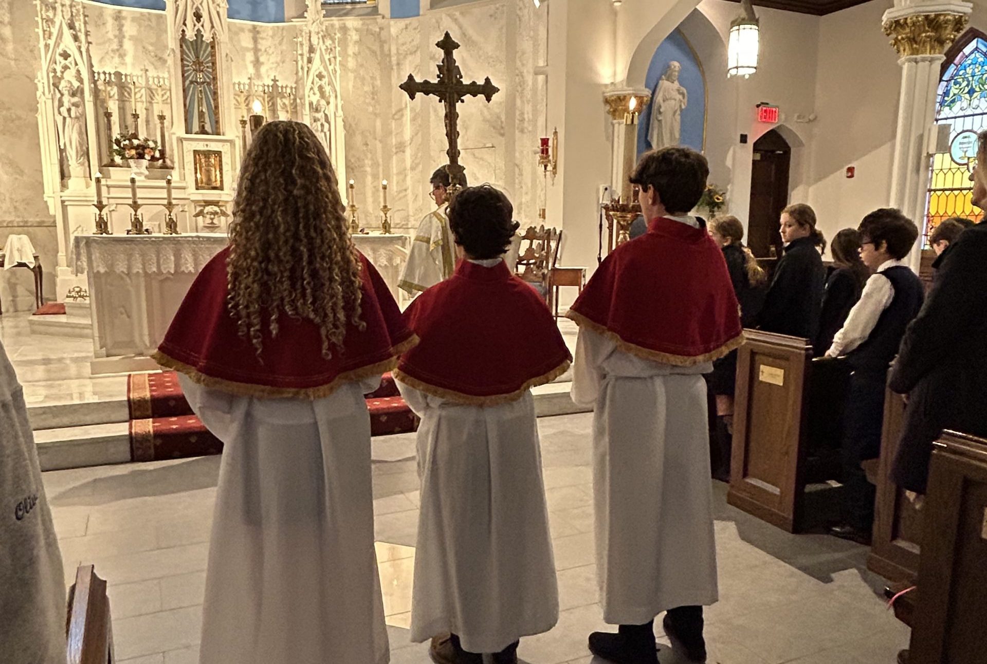 Three student altar servers at St. Mary Church on All Saints Day, 2023