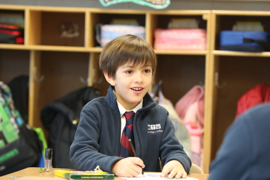 Grade 1 bo9y working at desk