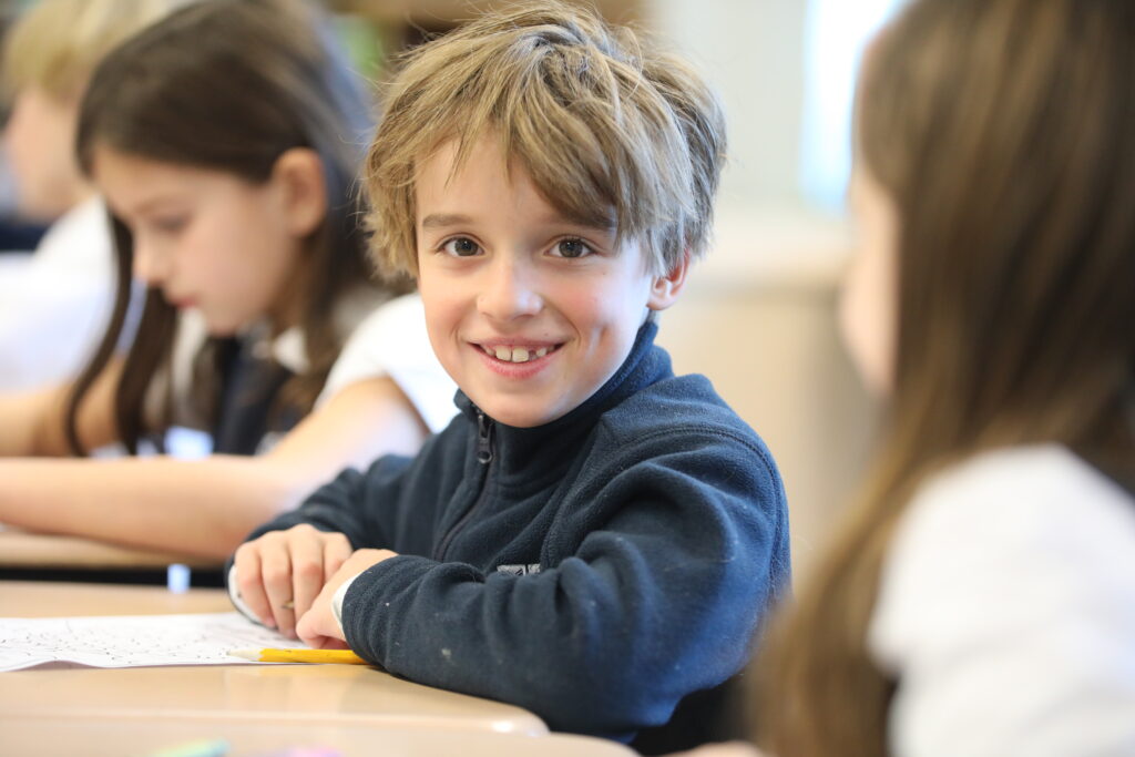 Smiling Grade 3 boy at desk