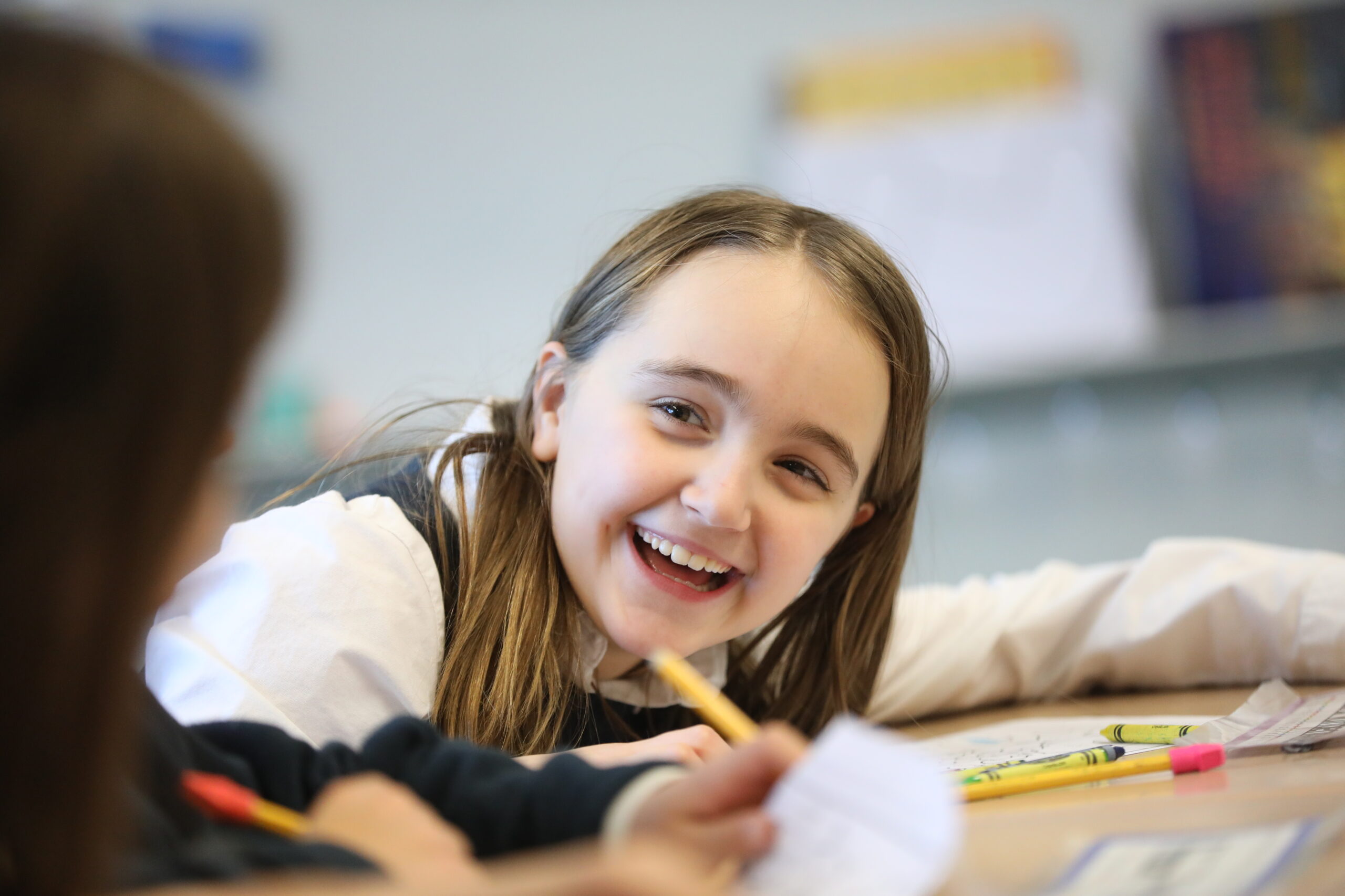 Grade 3 student smiling while working at her desk