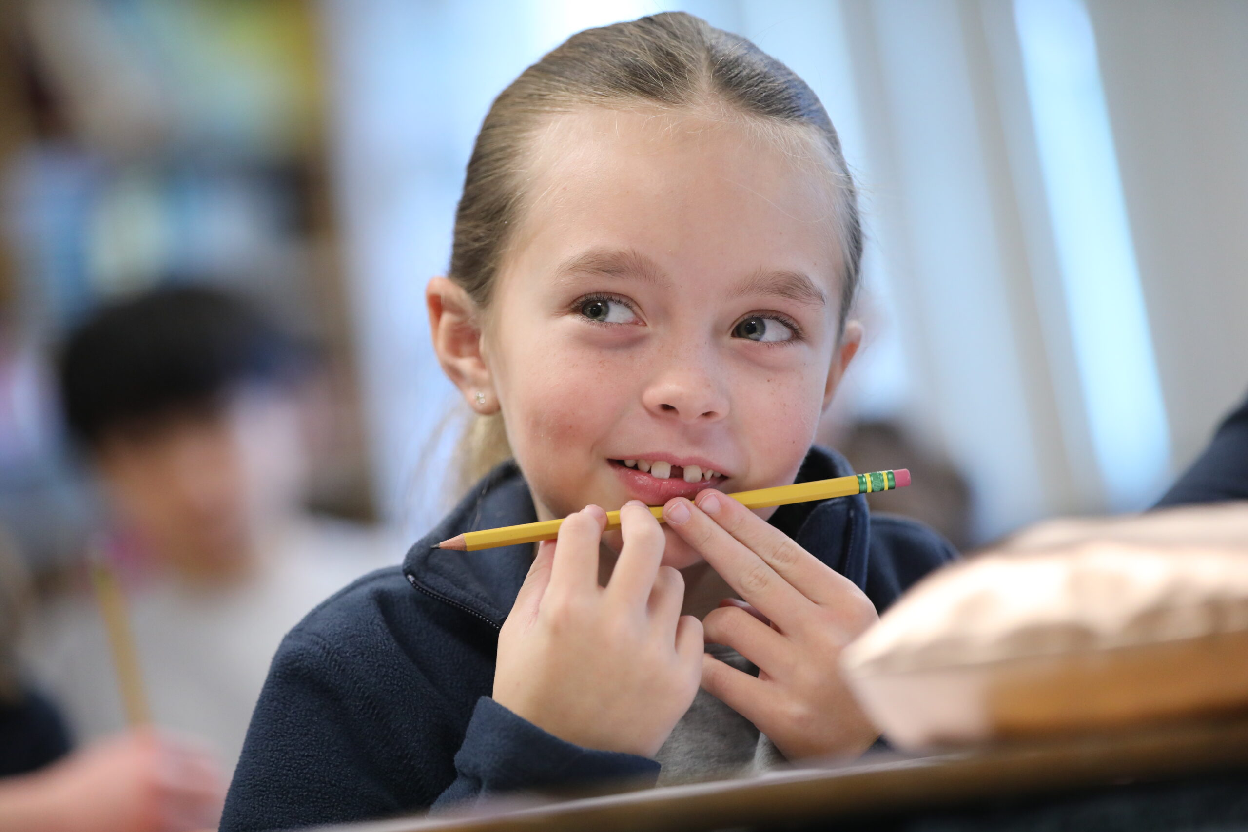 Elementary girl thinking with pencil inhands