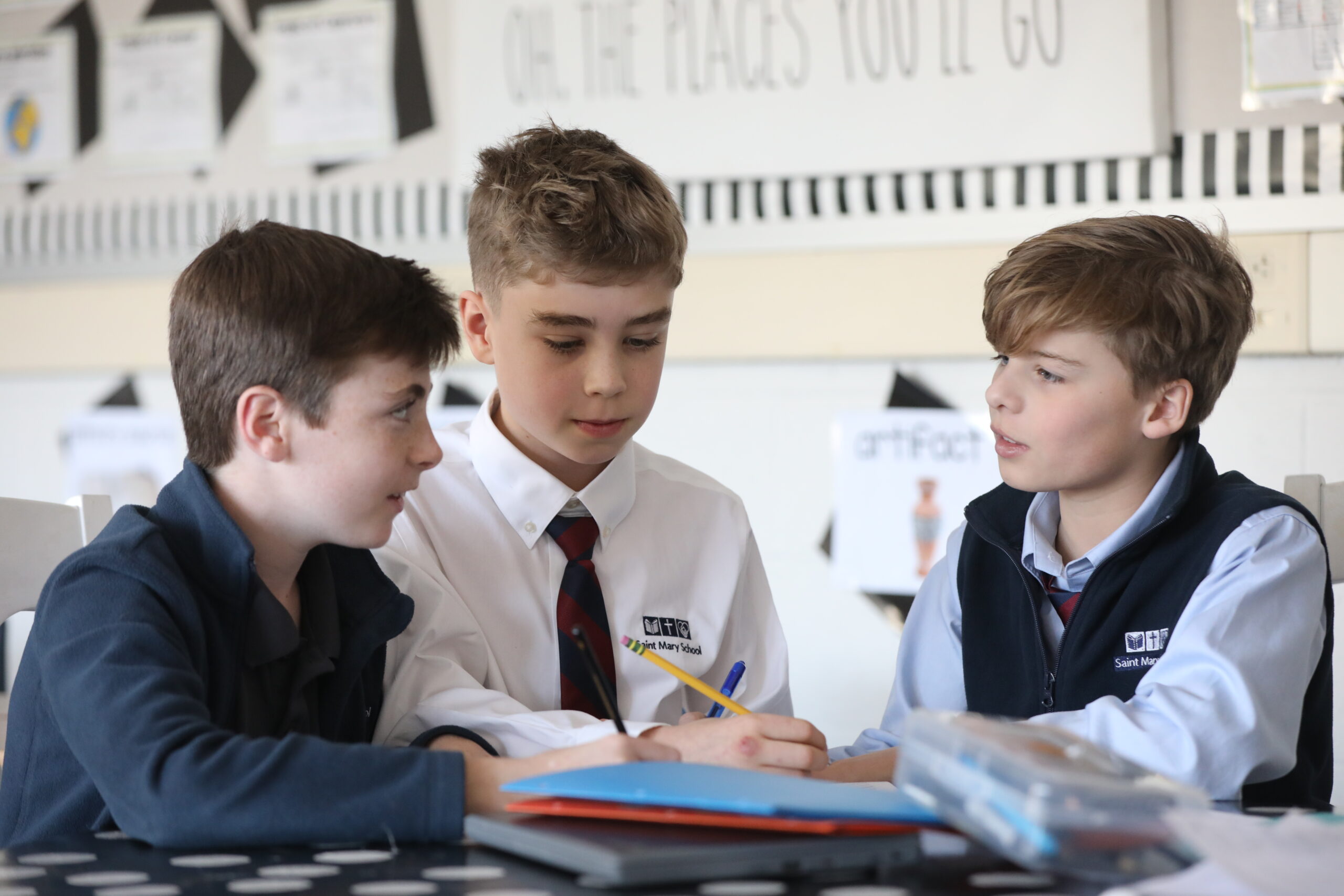 three middle school boys discussing social studies