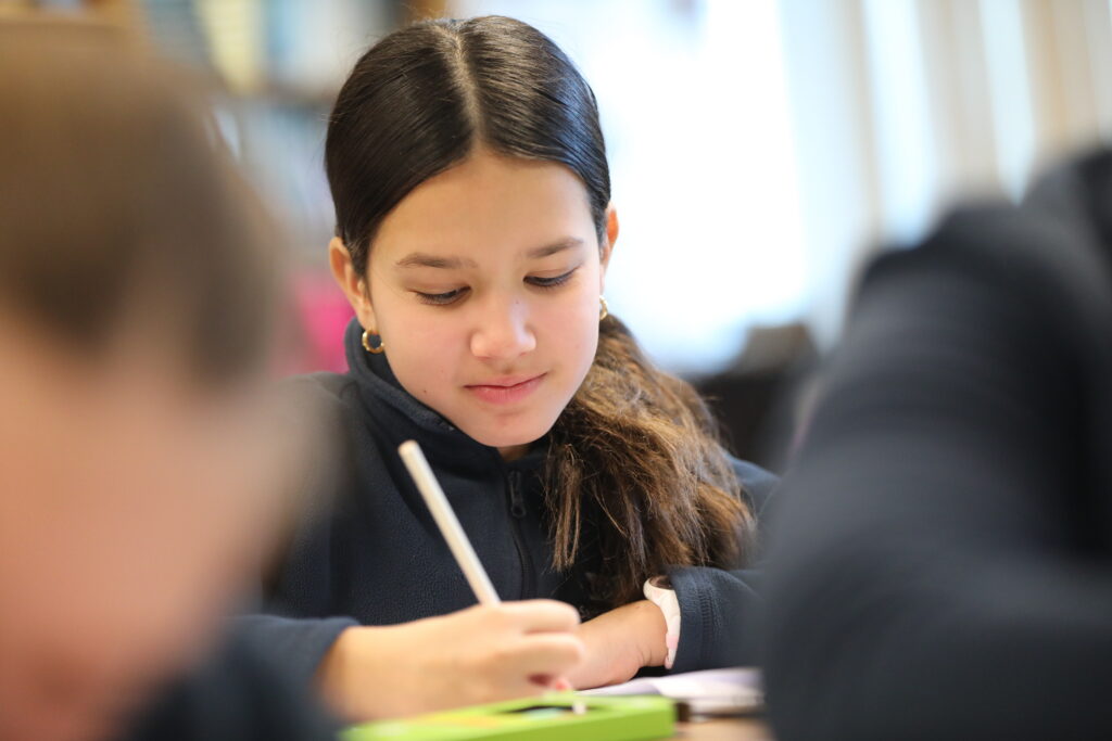 Elementary aged girl looking down while writing